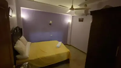 a room with a yellow bed and a purple wall at Tibs mountain view in Al Aqālitah