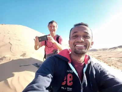 a man taking a picture of a woman in the sand at Reko Houses in Elephantine Island in Aswan