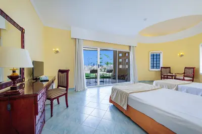 a hotel room with two beds and a balcony at Siva Golden Bay Makadi in Hurghada