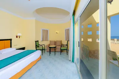 a hotel room with a bed and a table and chairs at Siva Golden Bay Makadi in Hurghada