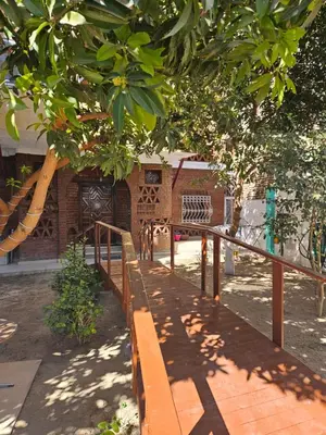 a wooden bench in front of a brick building at Casa Helvetica in Luxor