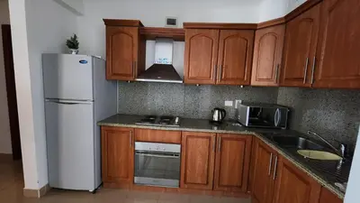a kitchen with wooden cabinets and a white refrigerator at apartment 2 bedrooms in the view in Hurghada