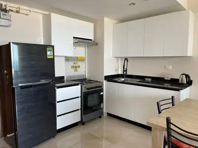 a kitchen with white cabinets and a black refrigerator at شقه بغرفه نوم في الغردقه in Hurghada