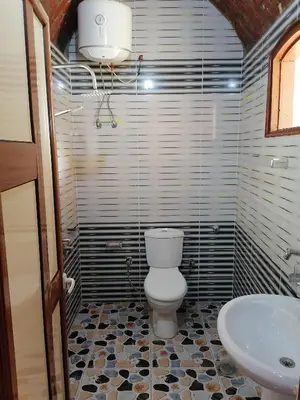 a bathroom with a toilet and a sink at Djorf apartments in Al Aqālitah