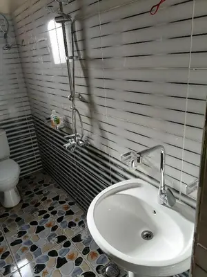a bathroom with a sink and a toilet at Djorf apartments in Al Aqālitah