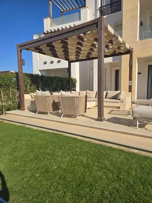 a patio with chairs and a wooden pergola at El Gouna, Cyan 2-Bedroom Ground Floor in El Gouna