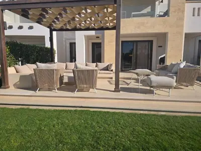 a patio with wicker chairs and a couch in front of a building at El Gouna, Cyan 2-Bedroom Ground Floor in El Gouna
