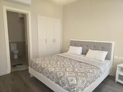 a bedroom with a bed and a bathroom with a toilet at El Gouna, Cyan 2-Bedroom Ground Floor in El Gouna