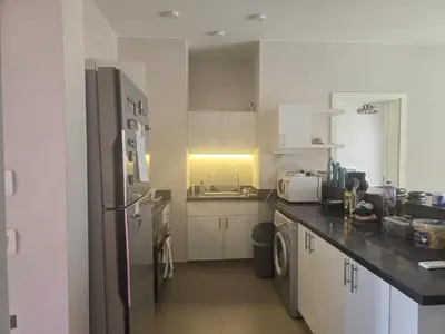 a kitchen with white cabinets and a refrigerator at El Gouna, Cyan 2-Bedroom Ground Floor in El Gouna