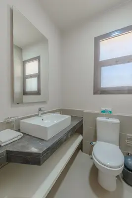 a bathroom with a sink and a toilet and a mirror at Cozy 2BR in Cyan, El Gouna Swiming Pool Access in Hurghada