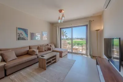 a living room with a couch and a large window at Cozy 2BR in Cyan, El Gouna Swiming Pool Access in Hurghada