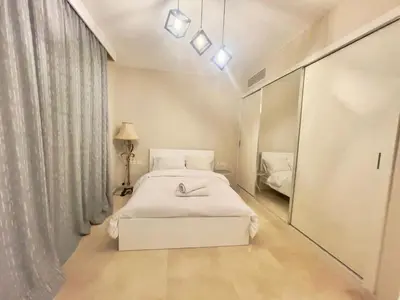 a white bedroom with a bed and a mirror at Mangroovy M7-4A-03 in Hurghada