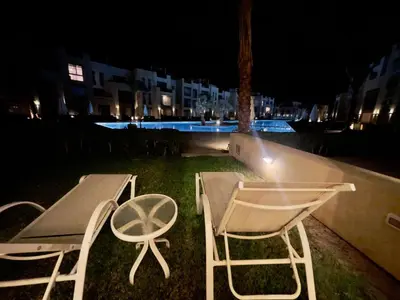 two chairs and a table and a table and chairs at night at Mangroovy M7-4A-03 in Hurghada