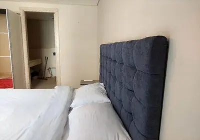 a bedroom with a bed with a blue headboard at Warm 1BR with at Mangroovy, El-Gouna M1-7B in Hurghada