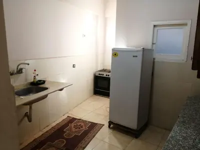 a small kitchen with a sink and a refrigerator at Ali habou {4} in Luxor