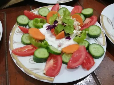 a plate of fruit and vegetables on a table at Ali habou {4} in Luxor