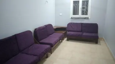 a living room with purple couches and a window at Ali habou {4} in Luxor