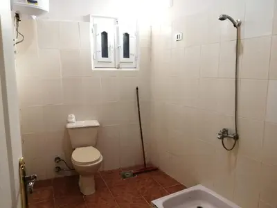 a bathroom with a toilet and a window and a tub at Ali habou {4} in Luxor