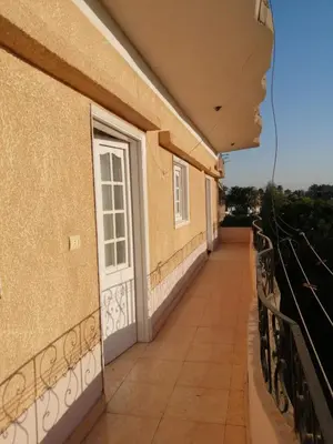 a balcony of a building with a white door at Ali habou {4} in Luxor