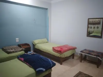 a room with three beds in a room at Ali habou {4} in Luxor