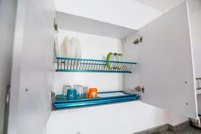 a kitchen pantry with plates and dishes on a shelf at la bonita studio in Hurghada
