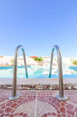a pool with two metal bars in front of a resort at la bonita studio in Hurghada