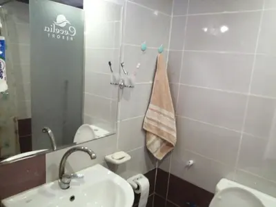 a bathroom with a sink and a toilet and a mirror at Chalet front the beach in Hurghada