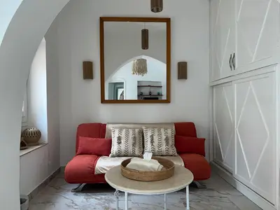a living room with a red couch and a table at Casa Della Laguna in Gouna in Hurghada