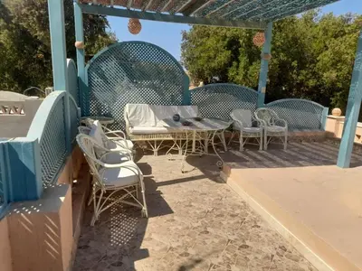 a patio with a table and chairs under a pergola at Casa Della Laguna in Gouna in Hurghada
