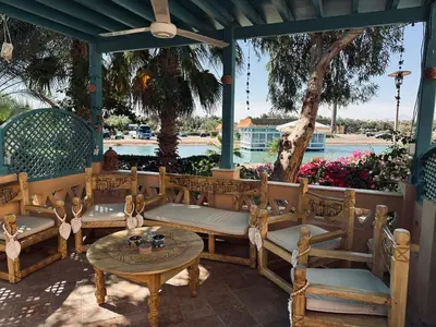 a porch with benches and a table and a view of the water at Casa Della Laguna in Gouna in Hurghada