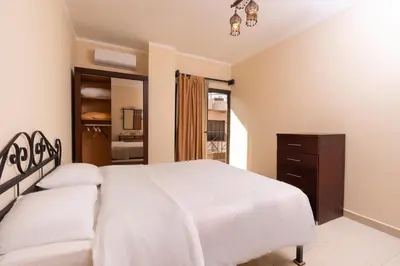 a bedroom with a large white bed and a dresser at 2bedrooms apartment 53 in Hurghada