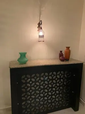 a table with vases and a light on a wall at 2bedrooms apartment 53 in Hurghada