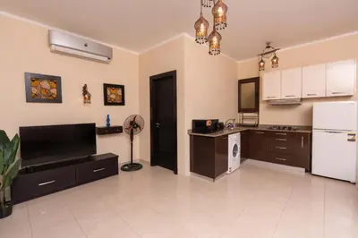 a kitchen with brown cabinets and a white floor at 2bedrooms apartment 53 in Hurghada