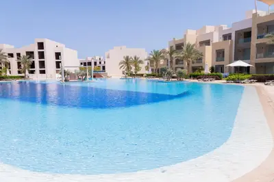 a large swimming pool in the middle of a resort at Modern apartment with large pool & beach access in Hurghada