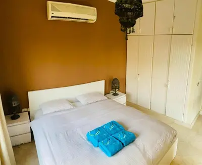 a bedroom with a white bed with two blue boxes on it at Nubian Style Apartment, South Marina, El Gouna in Hurghada
