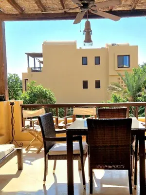 a table and chairs on a balcony with a building at Nubian Style Apartment, South Marina, El Gouna in Hurghada
