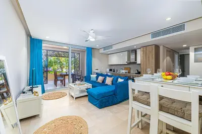 a kitchen and a living room with a blue couch at Modern apartment with great Pool & Beach access in Hurghada