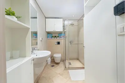 a bathroom with a shower and a sink and a toilet at Modern apartment with great Pool & Beach access in Hurghada