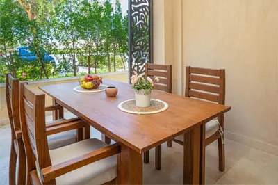 a wooden table with chairs and a bowl of fruit on it at Modern apartment with great Pool & Beach access in Hurghada