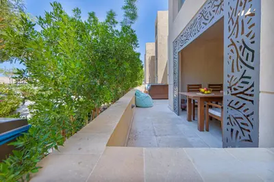 a patio with a wooden table and some plants at Modern apartment with great Pool & Beach access in Hurghada