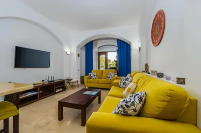 a living room with a yellow couch and a tv at Style Apartment in nubian design at lagoon in Hurghada
