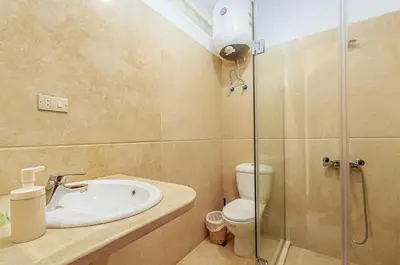 a bathroom with a shower and a sink and a toilet at Style Apartment in nubian design at lagoon in Hurghada
