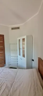a white bedroom with a bed and a closet at Hurghada Cosy Apart in Hurghada