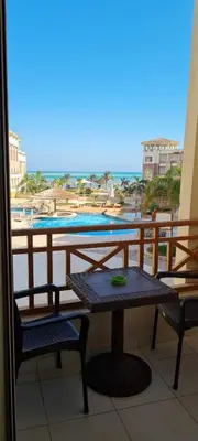 a table and chairs on a balcony with a view of the ocean at Hurghada Cosy Apart in Hurghada
