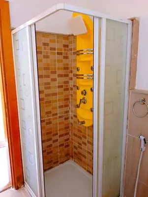 a shower in a bathroom with a yellow shower at Шале Stella di mare Makadi Хургада in Hurghada