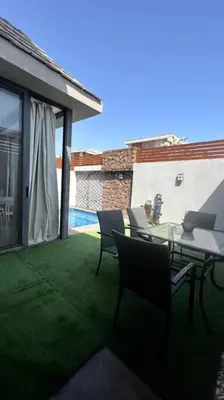 a patio with a table and chairs on the grass at 1BR villa - private heated pool in Bali ElGouna in Hurghada