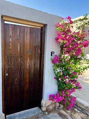 a wooden door with a bush of flowers next to a building at 1BR villa - private heated pool in Bali ElGouna in Hurghada