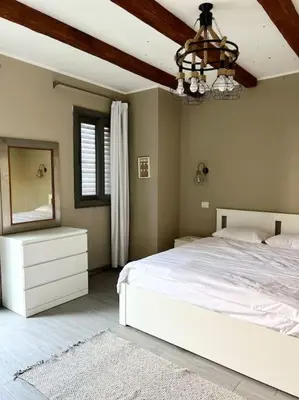 a bedroom with a white bed and a mirror at 1BR villa - private heated pool in Bali ElGouna in Hurghada