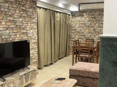 a living room with a brick fireplace and a table at Hurghada-Magawish Villa 4 in Hurghada