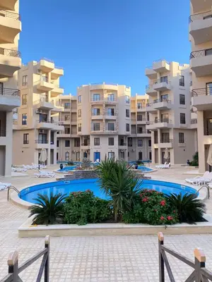 a swimming pool in front of some apartment buildings at Ubytovani v novém resortu Aqua Tropical poblíž El Gouny in Hurghada
